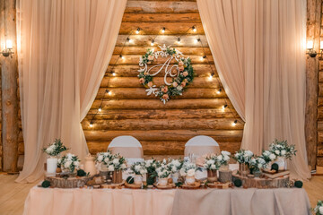 Wedding decor  in rustic style. The newlyweds' table decorated with bouquets of white roses,...