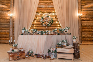 Wedding decor  in rustic style. The newlyweds' table decorated with bouquets of white roses,...