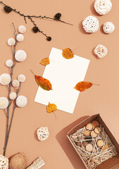Autumn background with fall winter decor, blank stationary template, invitation mock up, empty paper card with copy space for text from top on beige background. Top view. Flat lay. Fall winter seasons