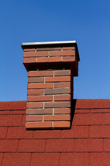 Red brick chimney on red roof