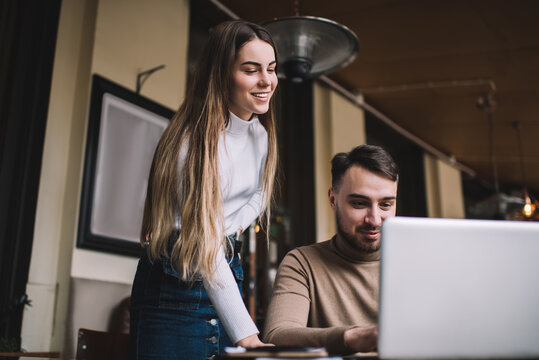 Young man in casual clothing working remotely with female colleague