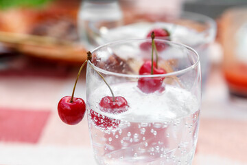Cherries in a glass with mineral sparkling water