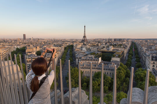 Woman photographing view, The Eiffel Tower and Paris skyline, France