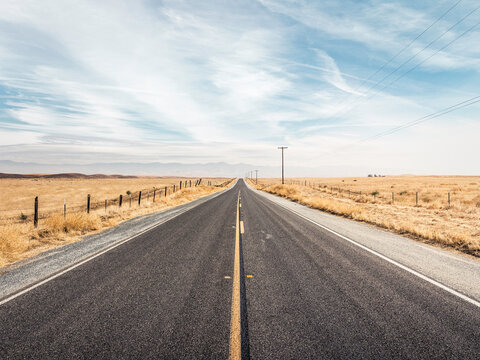 Diminishing highway through plain landscape, California, USA