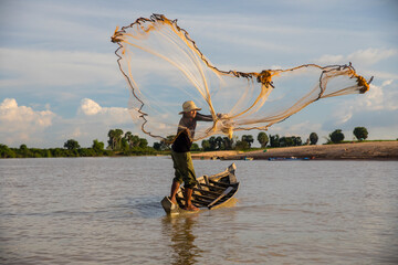 Local fisherman throwing net on Steung Saen River, Kampong Thum, Cambodia