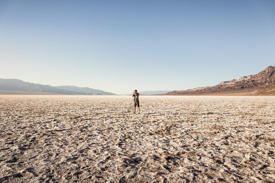 Man taking photograph, Badwater Basin, Death Valley National Park, Furnace Creek, California, USA