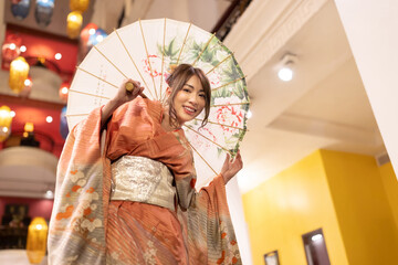 A girl wearing a kimono, Japanese culture with an umbrella,  looking at the camera. Japanese concept of kimono and yukata.