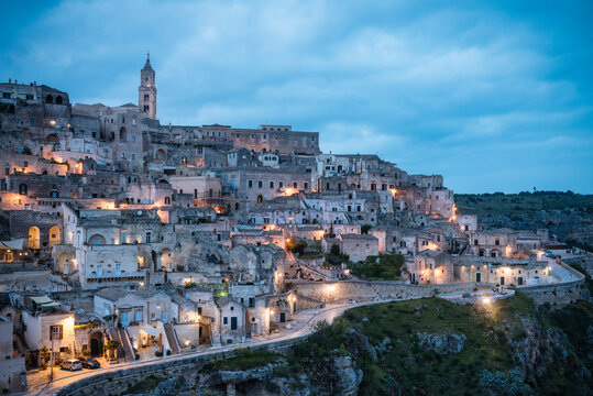 View of traditional building exteriors on hillside at dusk, Matera, Basilicata, Italy