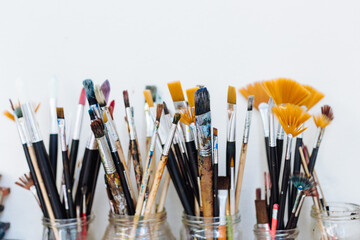 Still life of glass jars containing paintbrushes