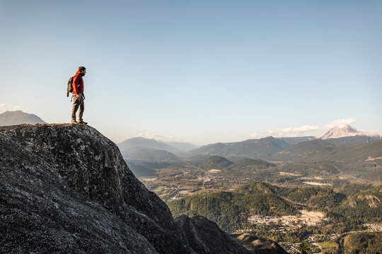 Man standing on mountain, looking at view, Stawamus Chief, overlooking Howe Sound Bay, Squamish, British Columbia, Canada