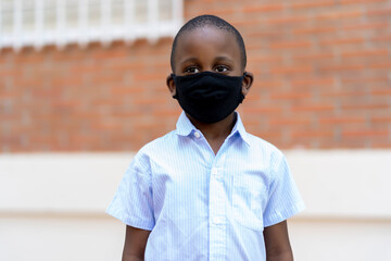 African boy using his mask to go to school