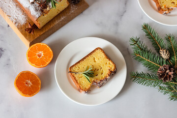 Winter bakery. Citrus loaf moist cake decorated with tangerines, rosemary, spices and sugar powder....