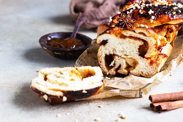 Swirl brioche with apricot jam, nuts, cinnamon and anise star. Braided or roll bread, Babka. Stone...