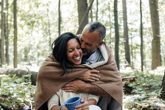 Smiling man kissing his partner at campsite