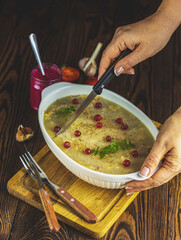 Woman cutting preparing tasty jelly with meat, beef aspic, traditional Russian food in white dish,...