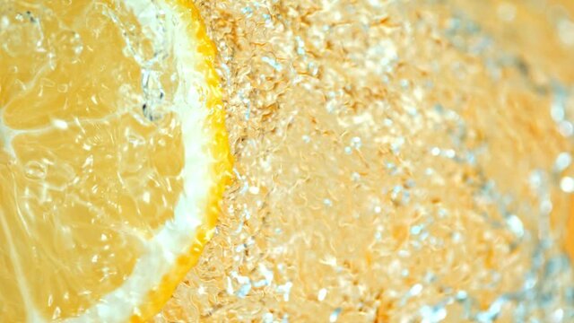 Super Slow Motion Shot of Splashing Water on Rotating Lemon Slice at 1000fps.