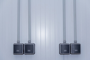 The waterproof light switch is mounted on the sandwich panel wall. Electrical equipment in a production building.