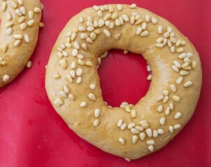 Homemade sesame bagels on red culinary latex. Composition in natural light