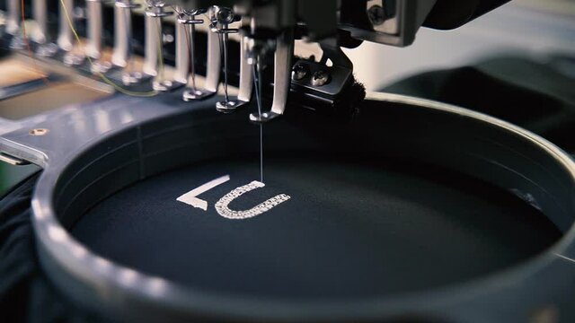 Stickmaschine / N&auml;hmaschine stickt Logo auf Textil Stoff / Slow Motion