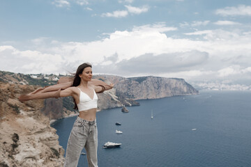 pretty woman on the edge on mountain on sea and sky background. summer nature. beauty portrait
