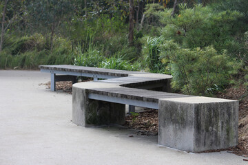 Timber and concrete zig zag bench seating with bush land in the background at Sydney Park