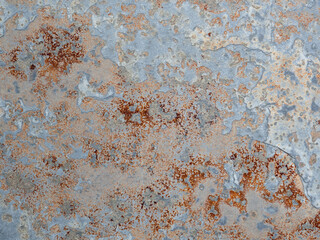 Texture of wall with brass and aqua patina. Blue silver surface with streaks of rust. Rusty corrosion. Brown, grey, blue and orange rust on enamel. Corroded background.