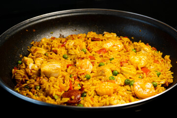 Sea Food Home made Paella Valenciana. Typical Spanish seafood paella in traditional pan. Macro close-up. Selective focus
