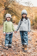 Little cute smiling girls walking together in autumn day. Friendship. Happy family concept