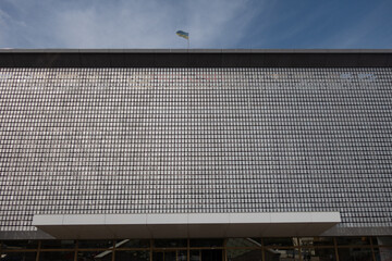 The kinetic facade of the building. Loose metal plates swing in waves in the wind.