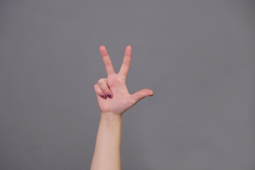 photo shot of victory sign of womens hand. Girl show two fingers.