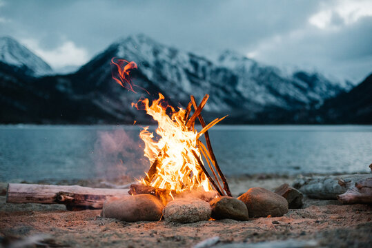 View of campfire burning by lake