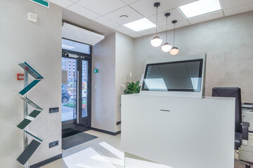 White reception corner with high-tech office equipment.