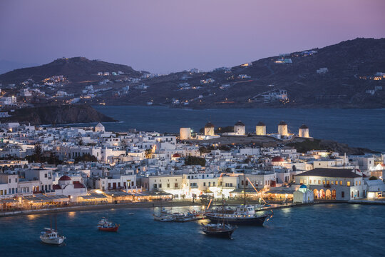 View of illuminated town by sea