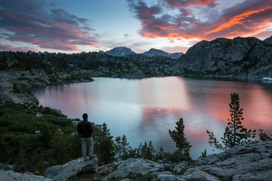 Rear view of man looking at view while standing on rock