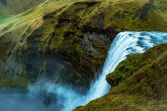 View of Skogafoss waterfall falling from cliff