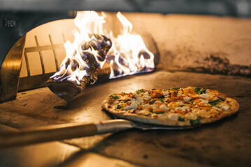 Pizza putting into woodfire stove