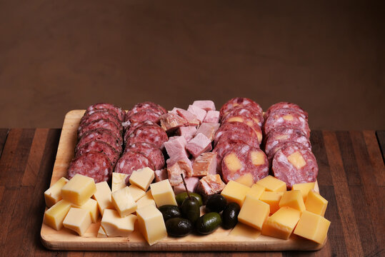 picada completa sobre tabla compuesta por salame, queso, salamín, lomo, jamón, aceitunas negras, fymbo, pategrás, lomo auhmado