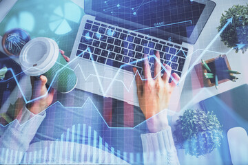 Double exposure of woman hands working on computer and forex chart hologram drawing. Top View. Financial analysis concept.