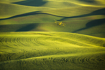 View of crop duster flying over field