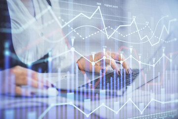 Double exposure of businesswoman hands typing on computer and forex graph hologram drawing. Financial analysis concept.