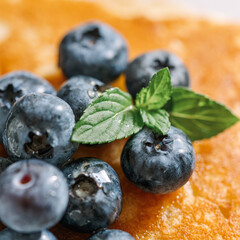 Homemade pancakes, fresh blueberries with maple syrup on white table. Healthy American breakfast or brunch, favorite meal. Close.