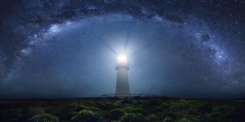 View of lighthouse against milky way at night