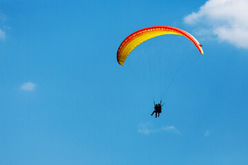Yellow Paraglider tandem instructor with a tourist flying into the sky with clouds on a sunny day. making a selfie
