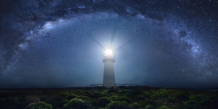 View of lighthouse against milky way at night