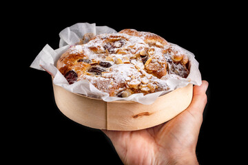 Tasty fruit cake in a paper mold held in the palm of your hand. Dessert prepared for serving.