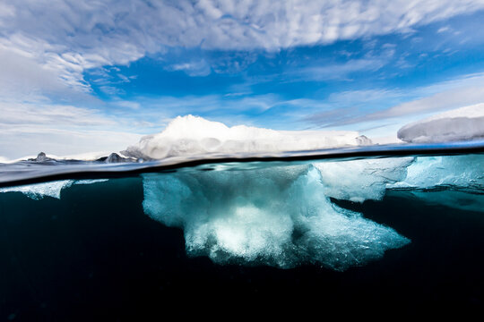 View of iceberg against cloudy sky