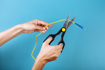Destroy optical fiber by scissors. Isolated on blue