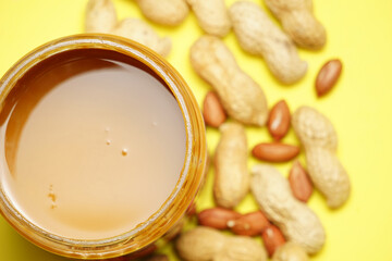 top view of peanut butter with peanuts in the background. flat lay