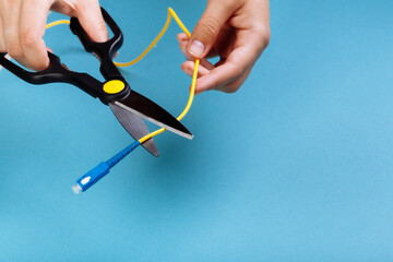 Destroy optical SC fiber by scissors. Isolated on blue