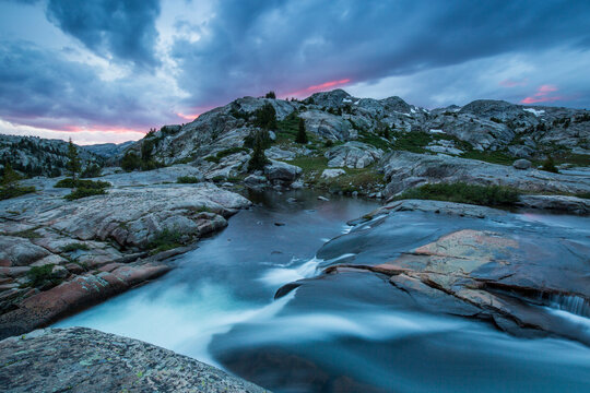 Scenic view of waterfall against cloudy sky during sunset